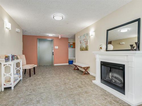 204-2380 Brethour Ave, Sidney, BC - Indoor Photo Showing Living Room With Fireplace