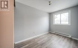 Spare room with baseboard heating and light wood-type flooring - 