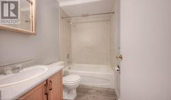 Full bathroom with vanity, toilet, wood-type flooring, and tiled shower / bath combo - 