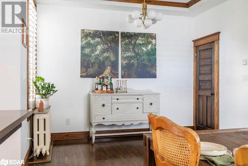 Living area with crown molding, radiator heating unit, dark hardwood flooring, and a notable chandelier - 109 Fairleigh Avenue S, Hamilton, ON - Indoor Photo Showing Dining Room