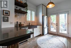 Kitchen with white cabinetry, light flooring, a wealth of natural light, and stainless steel appliances - 