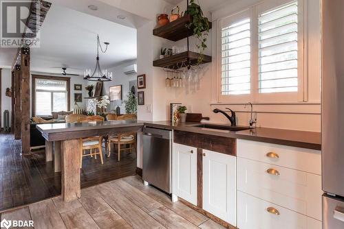 Kitchen featuring a wall mounted AC, sink, stainless steel dishwasher, white cabinetry, and light flooring - 109 Fairleigh Avenue S, Hamilton, ON - Indoor Photo Showing Kitchen