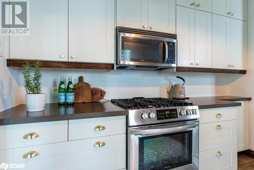 Kitchen with white cabinetry, appliances with stainless steel finishes, and light floors - 109 Fairleigh Avenue S, Hamilton, ON - Indoor Photo Showing Kitchen