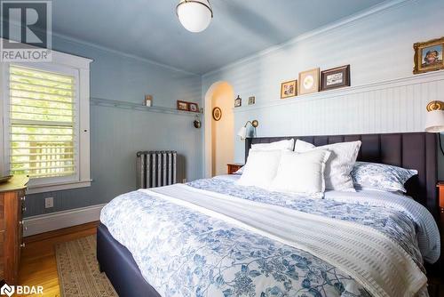 Bedroom featuring radiator, hardwood flooring, and ornamental molding - 109 Fairleigh Avenue S, Hamilton, ON - Indoor Photo Showing Bedroom