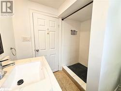 Bathroom featuring a tile shower, tile patterned flooring, and vanity - 