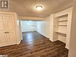 Basement featuring dark hardwood / wood-style floors and a textured ceiling - 