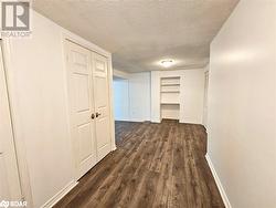 Hall featuring dark wood-type flooring and a textured ceiling - 