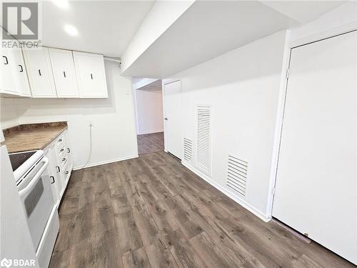 Kitchen with white cabinets, dark hardwood / wood-style flooring, and white electric range - 1306 Leighland Road Unit# Ll, Burlington, ON - Indoor Photo Showing Kitchen