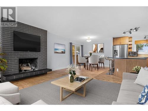 Main floor living, dining, kitchen *virtually staged - 3309 Mcmahon Road, West Kelowna, BC - Indoor Photo Showing Living Room With Fireplace