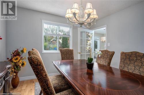 Dining area featuring wood-type flooring, a textured ceiling, and a chandelier - 134 Bayne Crescent, Cambridge, ON 