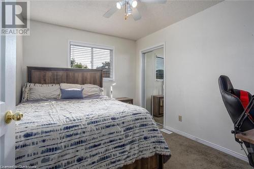 Carpeted bedroom with ceiling fan and a textured ceiling - 134 Bayne Crescent, Cambridge, ON 