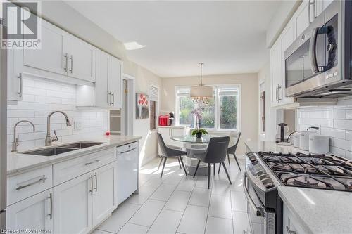 Kitchen featuring appliances with stainless steel finishes, an inviting chandelier, white cabinetry, and sink - 134 Bayne Crescent, Cambridge, ON 