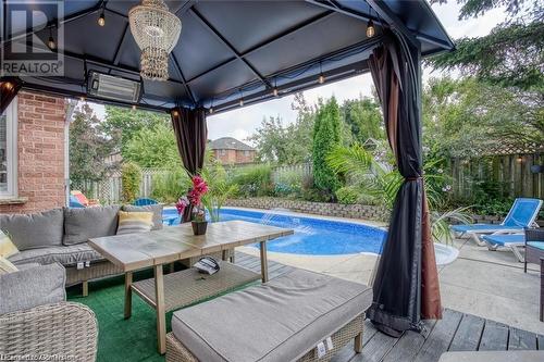 View of pool with pool water feature, an outdoor hangout area, and a wooden deck - 134 Bayne Crescent, Cambridge, ON 