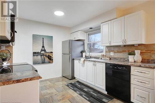 Kitchen with tasteful backsplash, stainless steel refrigerator, dishwasher, and white cabinets - 362 Blair Road, Cambridge, ON - Indoor Photo Showing Kitchen