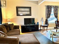 Living room featuring beamed ceiling and light hardwood / wood-style floors - 