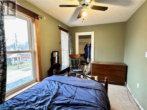 Carpeted bedroom featuring multiple windows, a textured ceiling, a closet, and ceiling fan - 57 Lowell Street N, Cambridge, ON - Indoor Photo Showing Bedroom