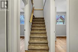 Stairs featuring a healthy amount of sunlight and wood-type flooring - 