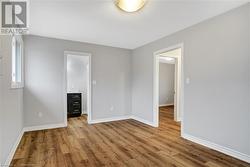 Unfurnished bedroom featuring a walk in closet and light hardwood / wood-style flooring - 