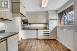 Kitchen with white cabinetry and light hardwood / wood-style floors - 