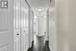 Corridor with a textured ceiling and dark wood-type flooring - 