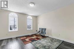 Sitting room with a textured ceiling and dark wood-type flooring - 