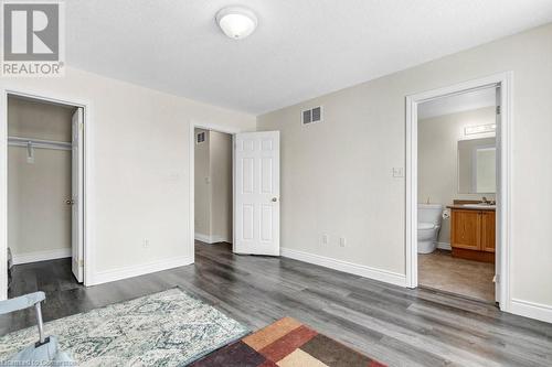 Unfurnished bedroom with sink, a textured ceiling, connected bathroom, dark hardwood / wood-style flooring, and a closet - 529 Victoria Road N, Guelph, ON - Indoor