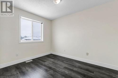 Empty room with a textured ceiling and dark hardwood / wood-style floors - 529 Victoria Road N, Guelph, ON - Indoor Photo Showing Other Room