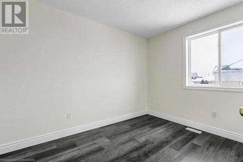 Unfurnished room featuring dark hardwood / wood-style flooring and a textured ceiling - 529 Victoria Road N, Guelph, ON - Indoor Photo Showing Other Room