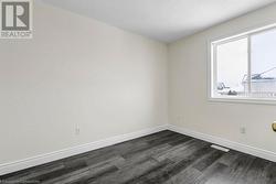 Unfurnished room featuring dark hardwood / wood-style flooring and a textured ceiling - 