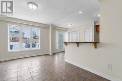 Unfurnished room featuring a textured ceiling and light tile patterned flooring - 