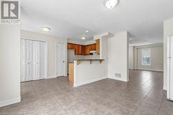 Kitchen featuring a breakfast bar, a textured ceiling, kitchen peninsula, and light tile patterned flooring - 