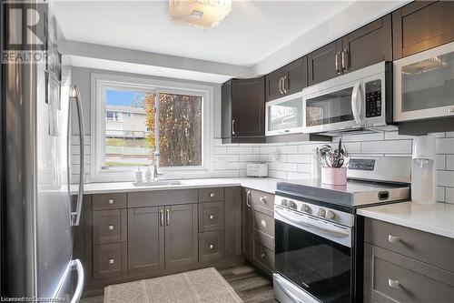 Kitchen featuring tasteful backsplash, dark brown cabinets, stainless steel appliances, dark wood-type flooring, and sink - 220 Salisbury Avenue Unit# 6, Cambridge, ON - Indoor Photo Showing Kitchen