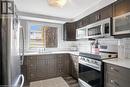 Kitchen featuring tasteful backsplash, dark brown cabinets, stainless steel appliances, dark wood-type flooring, and sink - 220 Salisbury Avenue Unit# 6, Cambridge, ON  - Indoor Photo Showing Kitchen 