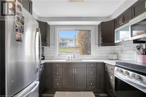 Kitchen featuring dark hardwood / wood-style flooring, stainless steel appliances, plenty of natural light, and sink - 220 Salisbury Avenue Unit# 6, Cambridge, ON - Indoor Photo Showing Kitchen