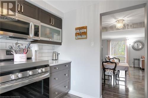 Kitchen with dark brown cabinets, dark wood-type flooring, appliances with stainless steel finishes, and tasteful backsplash - 220 Salisbury Avenue Unit# 6, Cambridge, ON - Indoor Photo Showing Kitchen