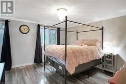 Bedroom featuring hardwood / wood-style floors, crown molding, and a textured ceiling - 