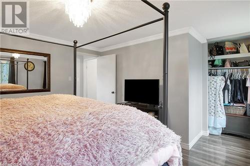 Bedroom featuring a closet, crown molding, hardwood / wood-style flooring, a textured ceiling, and a chandelier - 220 Salisbury Avenue Unit# 6, Cambridge, ON - Indoor Photo Showing Bedroom