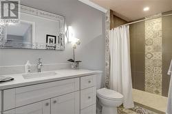 Bathroom with vanity, curtained shower, toilet, and ornamental molding - 