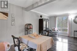 Dining area with beam ceiling, dark hardwood / wood-style flooring, and ornamental molding - 