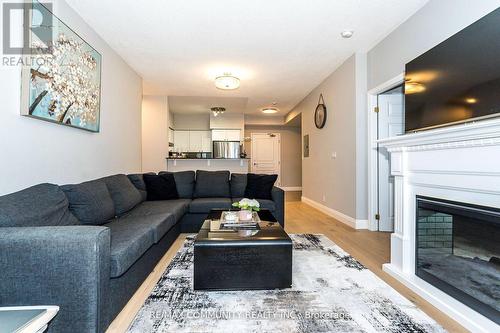 718 - 16 Dallimore Circle, Toronto, ON - Indoor Photo Showing Living Room With Fireplace