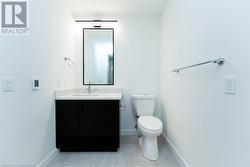 Bathroom featuring controlled heated porcelain floors, vanity, and toilet - 