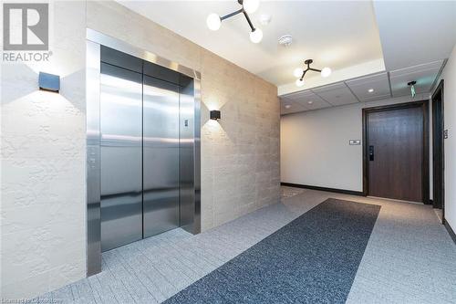 Corridor with carpet flooring and elevator for accessibility - 741 King Street W Unit# 301, Kitchener, ON - Indoor Photo Showing Other Room