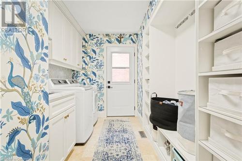 Laundry room with separate washer and dryer, light tile patterned floors, and cabinets - 659 Deervalley Road, Ancaster, ON - Indoor Photo Showing Laundry Room