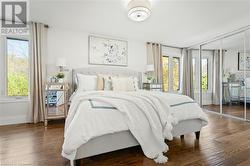 Bedroom featuring multiple windows, a closet, and dark hardwood / wood-style floors - 