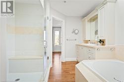 Bathroom with hardwood / wood-style floors, vanity, and shower with separate bathtub - 