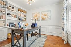 Office featuring a notable chandelier, light hardwood / wood-style floors, and ornamental molding - 