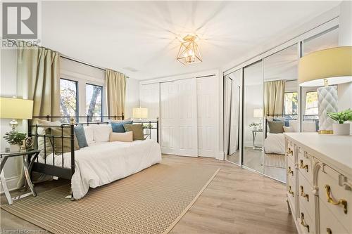 Bedroom featuring a notable chandelier, two closets, and light hardwood / wood-style flooring - 659 Deervalley Road, Ancaster, ON - Indoor