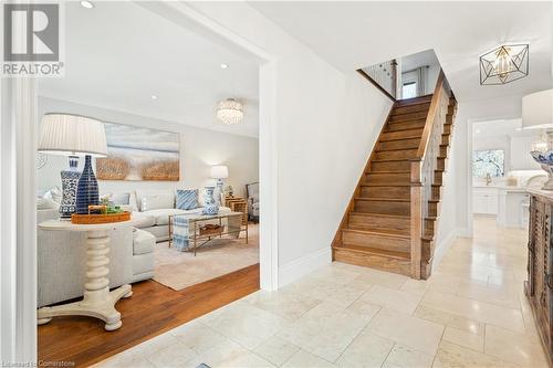 Stairs featuring hardwood / wood-style flooring and an inviting chandelier - 659 Deervalley Road, Ancaster, ON - Indoor