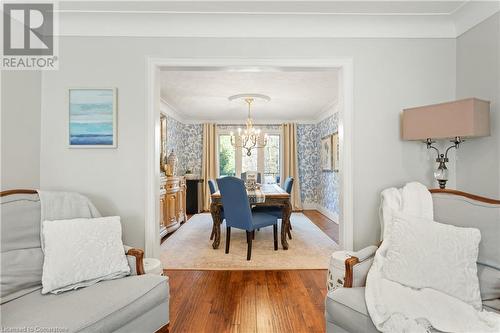 Dining space featuring hardwood / wood-style flooring, crown molding, and a notable chandelier - 659 Deervalley Road, Ancaster, ON - Indoor