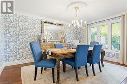 Dining space with crown molding, light hardwood / wood-style floors, and an inviting chandelier - 